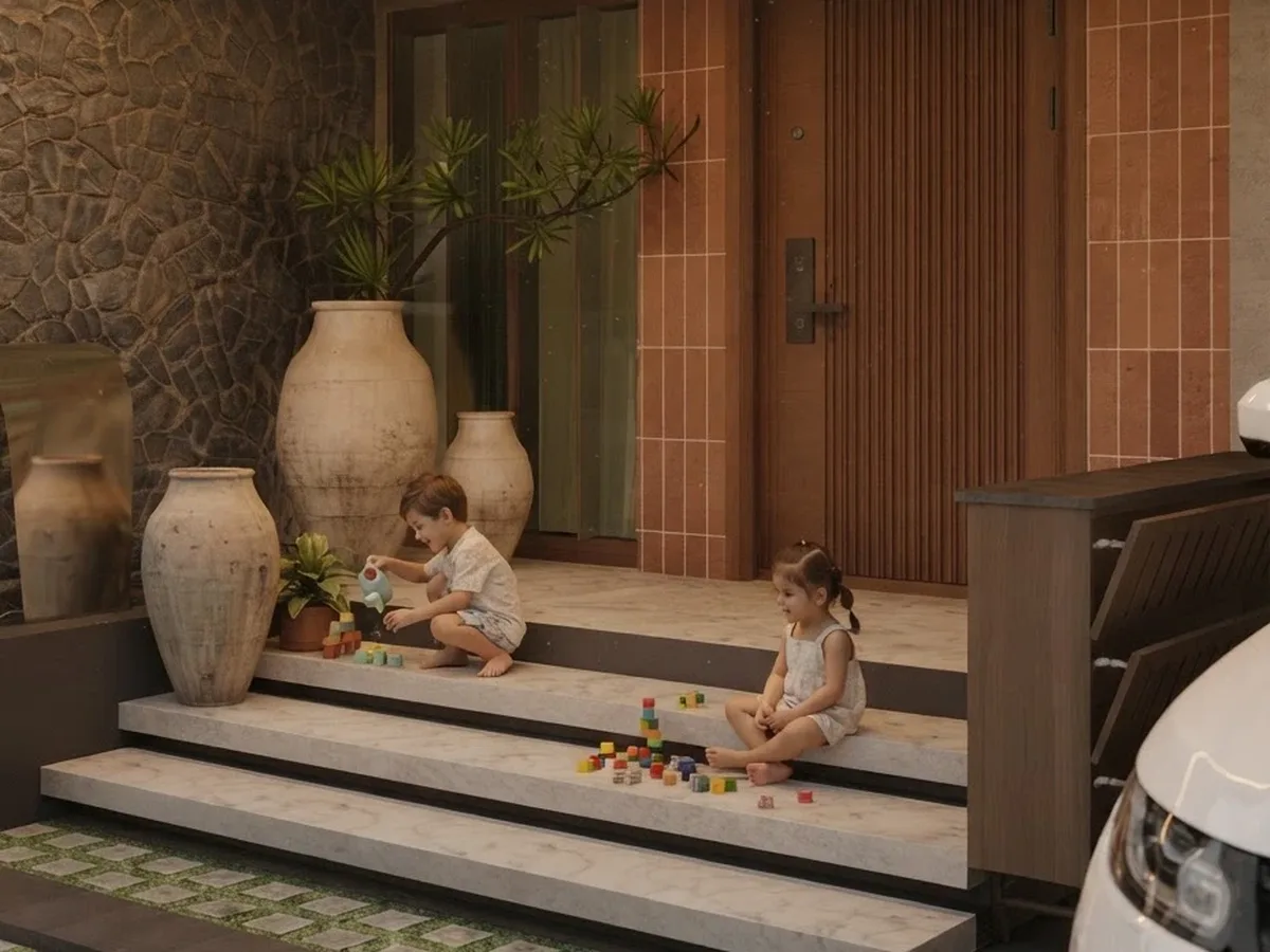3D render of a main entrance of a Kerala home with a stone feature wall, wide steps, clay pots and a wooden main door, designed by Oranzai Builders